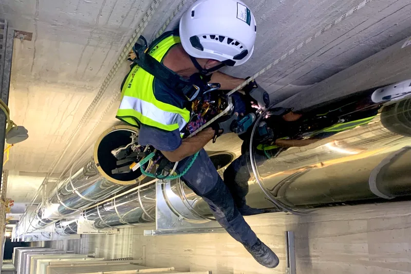IRATA rope-access engineer carrying out high-level flue installation work